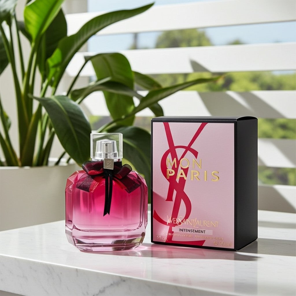 AuraGlow YSL Mon Paris Intensement perfume bottle with a black bow next to its pink and black box on a marble table.
