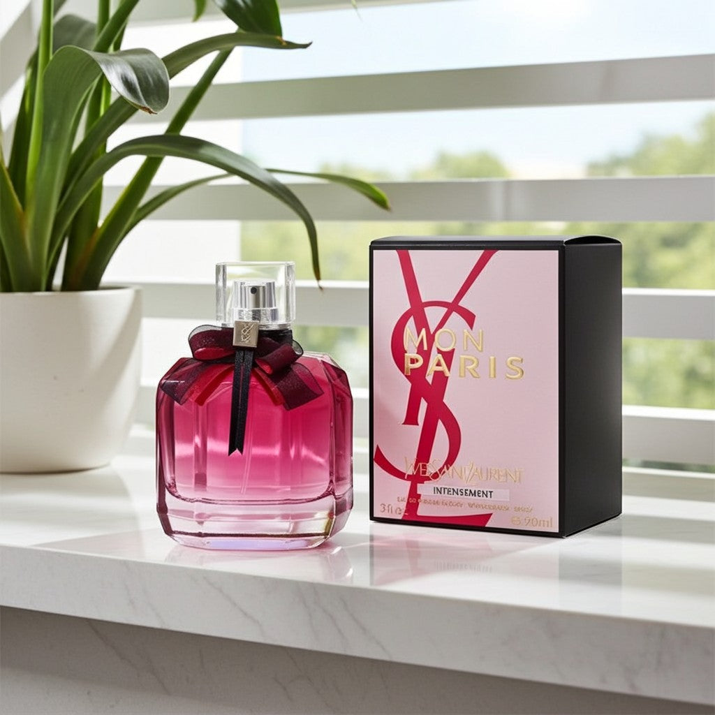 AuraGlow YSL Mon Paris Intensement perfume bottle with a dark pink bow next to its pink and black box on a windowsill.